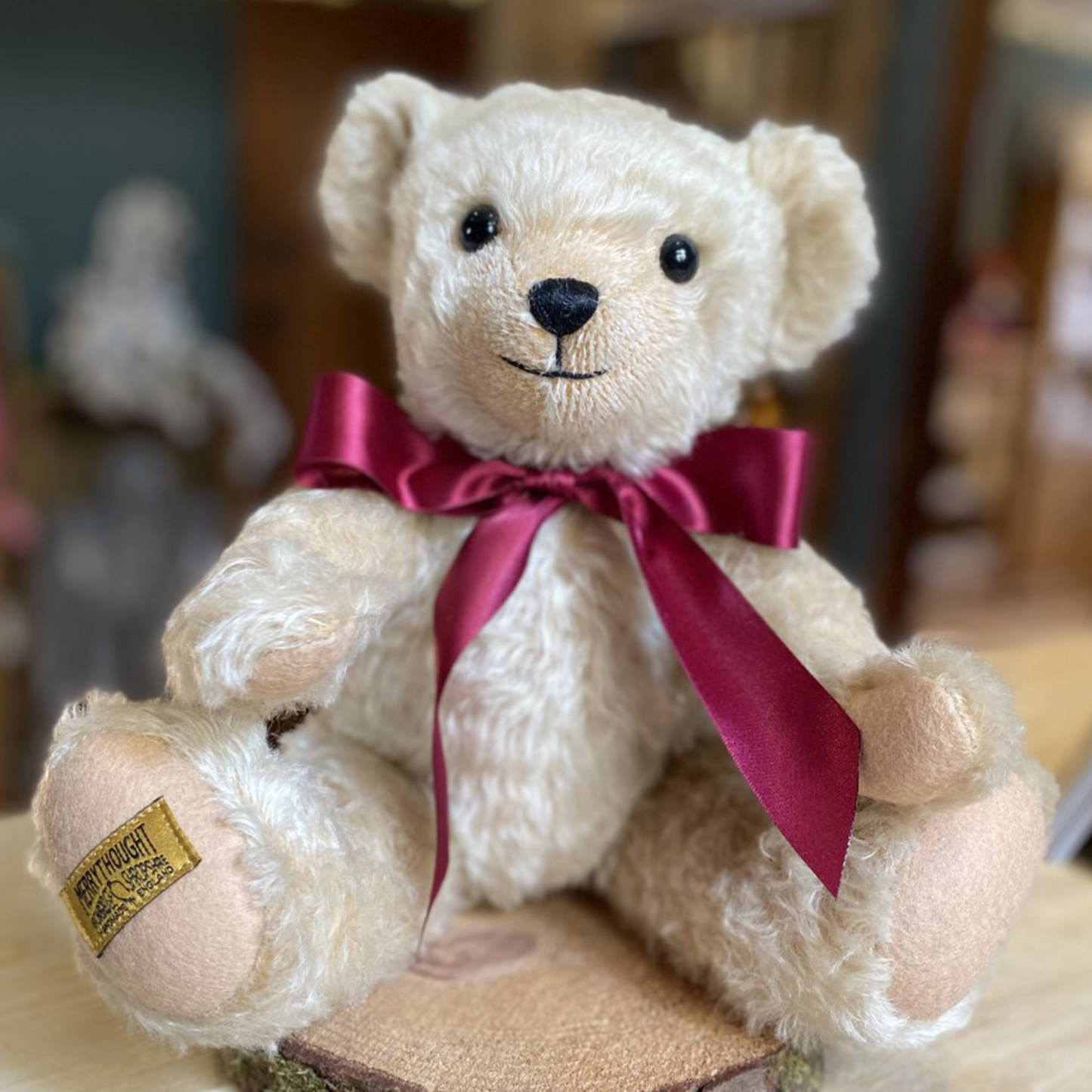 Henley's rich cream mohair has been carefully worked with pinky-beige wool felt, both complemented by an opulent burgundy satin bow. This adorable teddy bear's beaming smile is highlighted by a short-trimmed muzzle, giving him a friendly personality that all will fall in love with.  Each Merrythought soft toy in the Traditional Collection is presented with a drawstring bag, to help keep your new companion clean and dust-free.