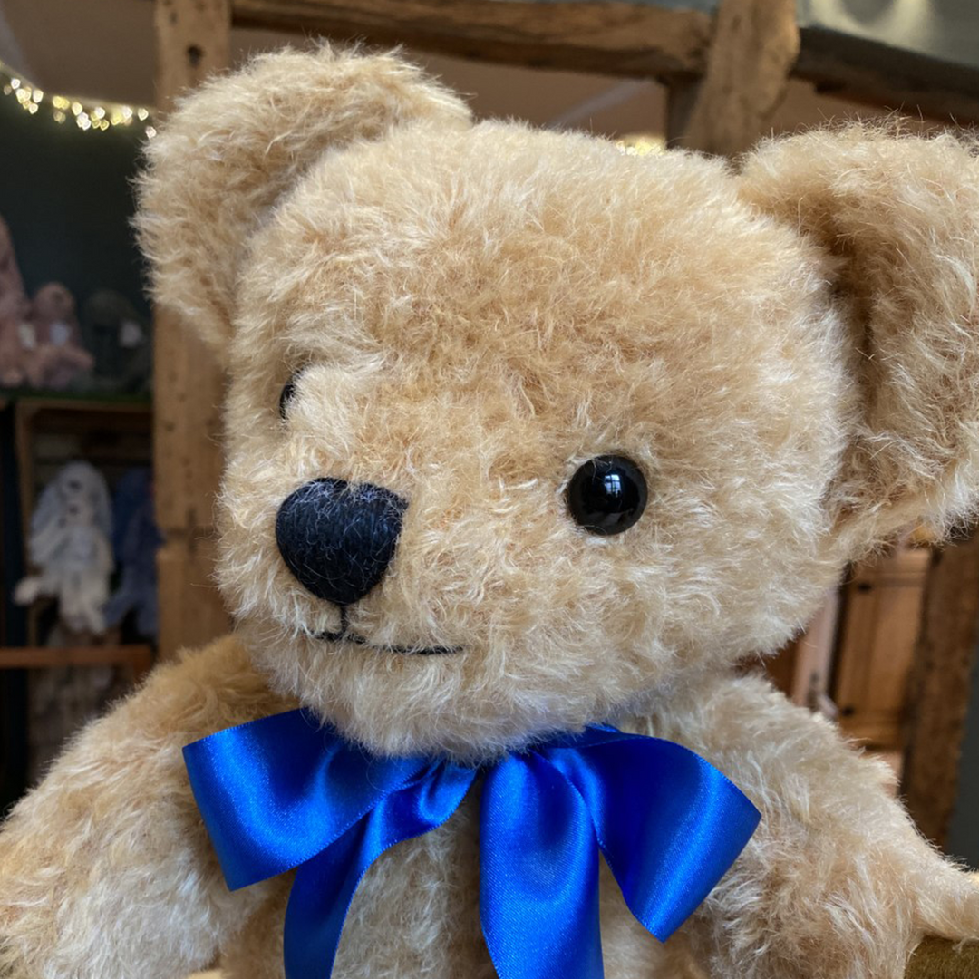 This charming traditional teddy bear has similar broad appeal to his cousin, London Gold. Based on the same distinctive patterns, and featuring light gold distressed mohair and a warm smile, London Curly Gold is the ideal companion for all ages. Oak-brown wool felt paws and a royal blue satin ribbon complete his exquisite design.