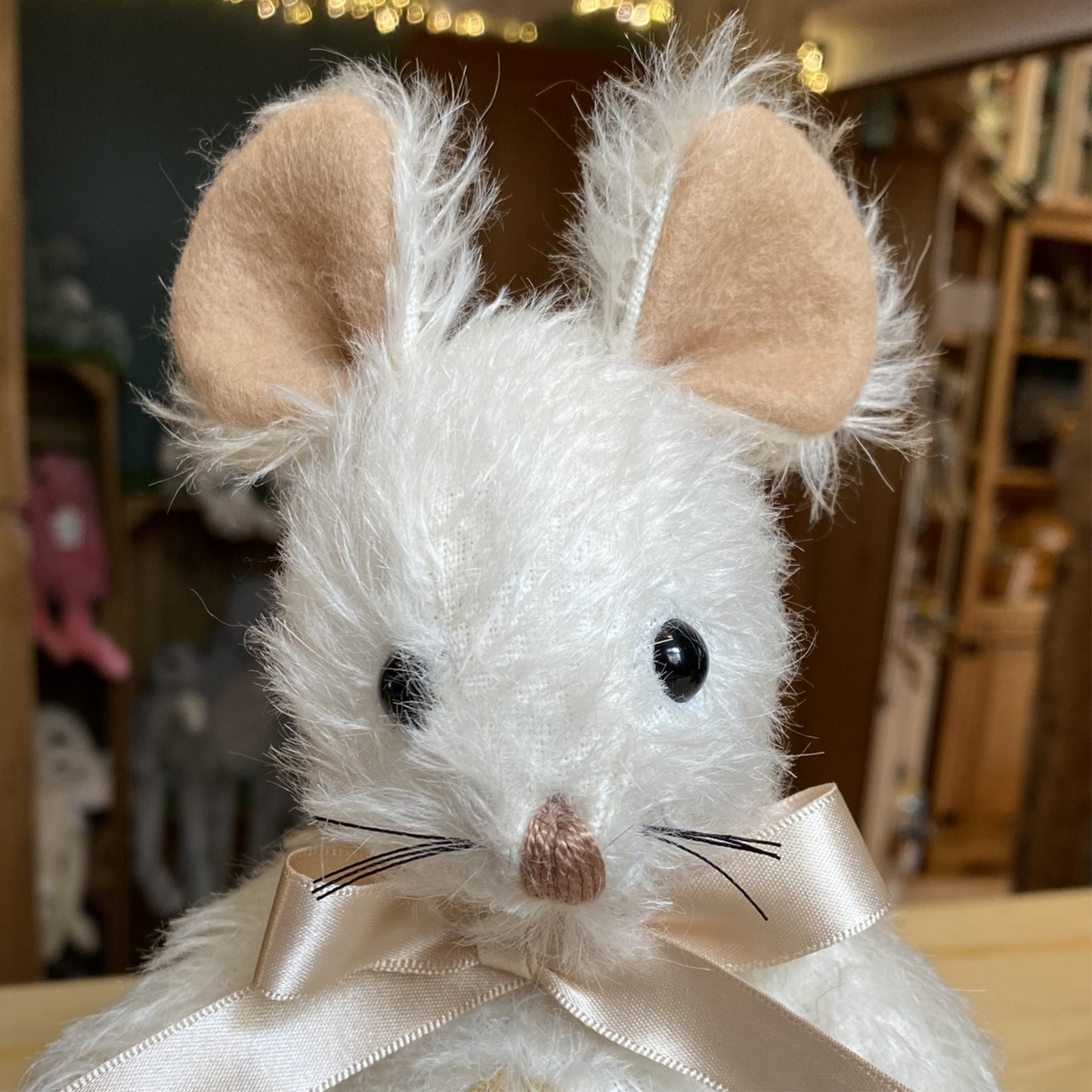 This characterful mouse has a particularly appealing expression, featuring hand-sewn whiskers and a little pinky nose. Her pure white mohair subtly contrasts a peachy-beige tummy, wool felt paws and slender tail.  Each Merrythought soft toy in the Traditional Collection is presented with a drawstring bag, to help keep your new companion clean and dust-free.
