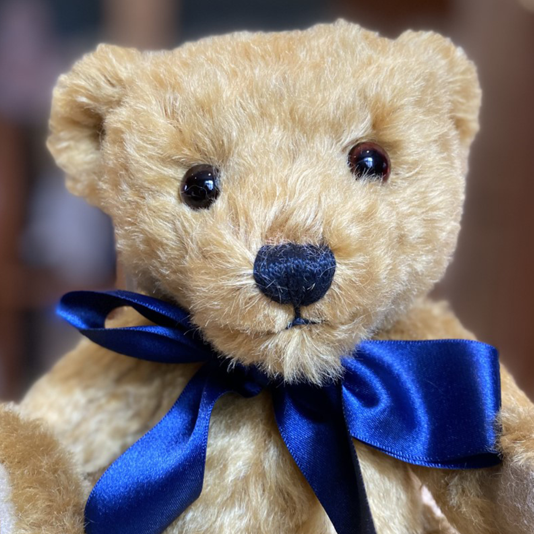 Crafted from wonderfully soft, rich golden mohair, Oxford's rotund shape and characterful dark brown eyes are guaranteed to warm hearts across the generations. His colours coordinate perfectly with dark sand wool felt paws and a splendid navy blue satin bow to finish.